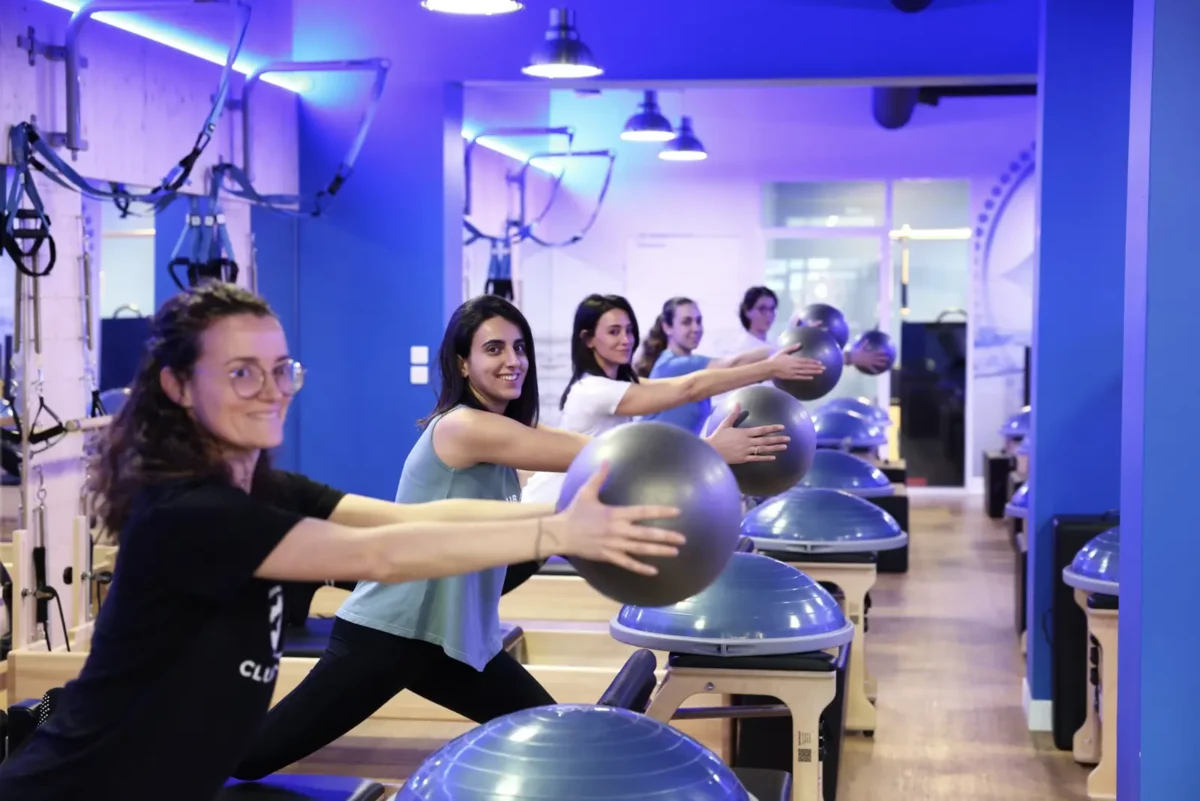 Des élèves travaillent avec un ballon sur le Bosu, au studio Club Pilates