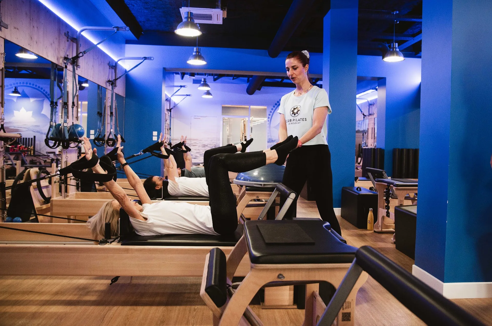 Un cours de Pilates Reformer au studio Club Pilates, jambes dans les sangles